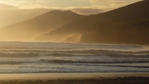 A coastal landscape with waves, a beach, and mountains in the background. - Mountainside Cottage, Dingle Wild Atlantic Way , Ireland (Dingle)