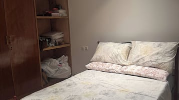 Une chambre à coucher comprenant un lit, une armoire et une étagère.