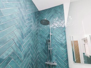 Eine Dusche mit Wandfliesen im Fischschuppenmuster.
