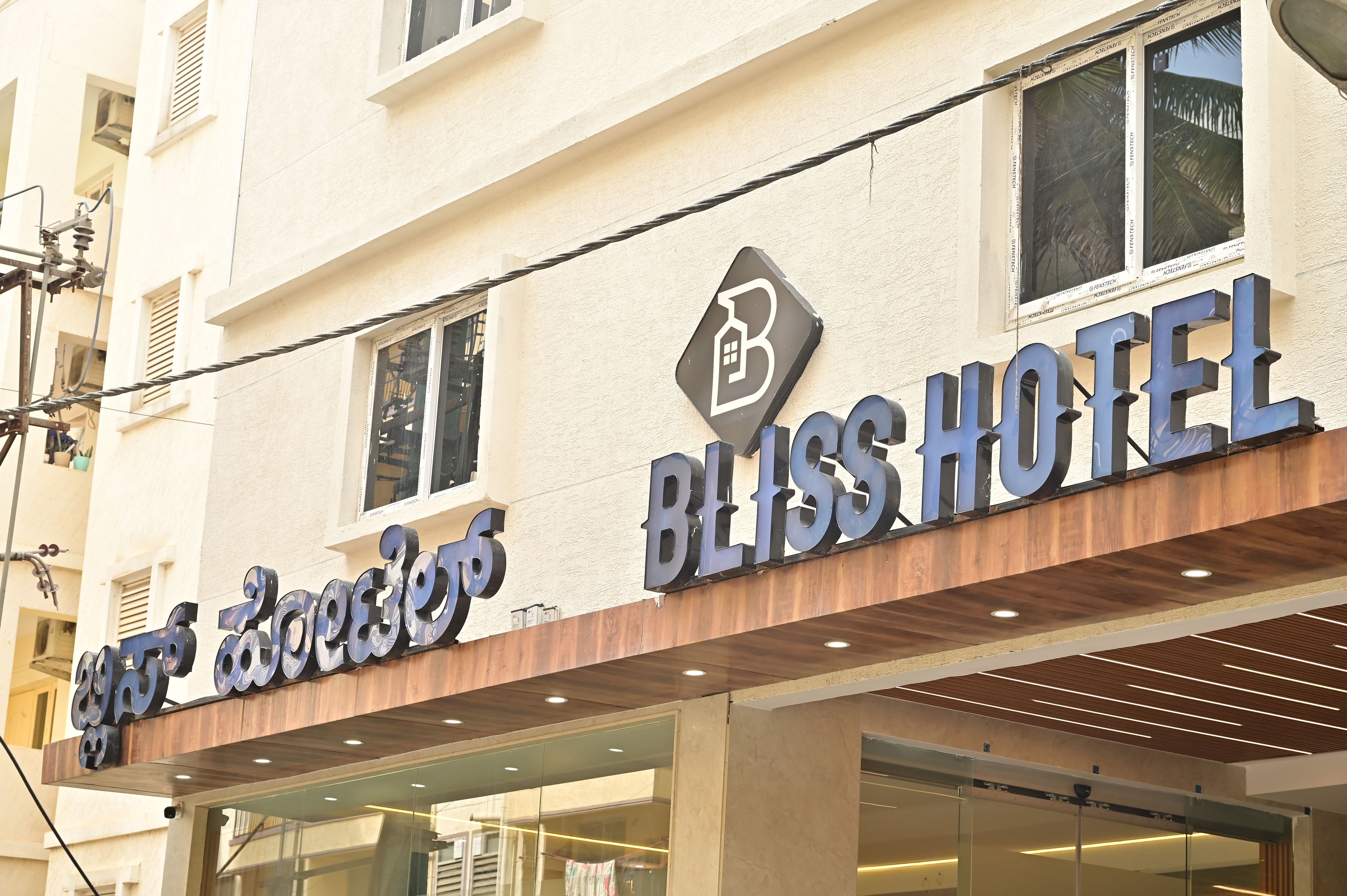 A hotel sign with the name 'BLISS HOTEL' and a logo above it.