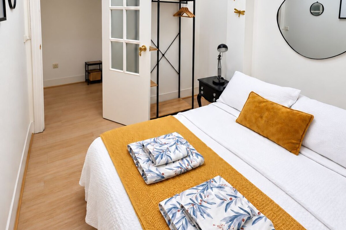 A hotel room with a bed, a bedside table, a wardrobe, and a ceiling light fixture.