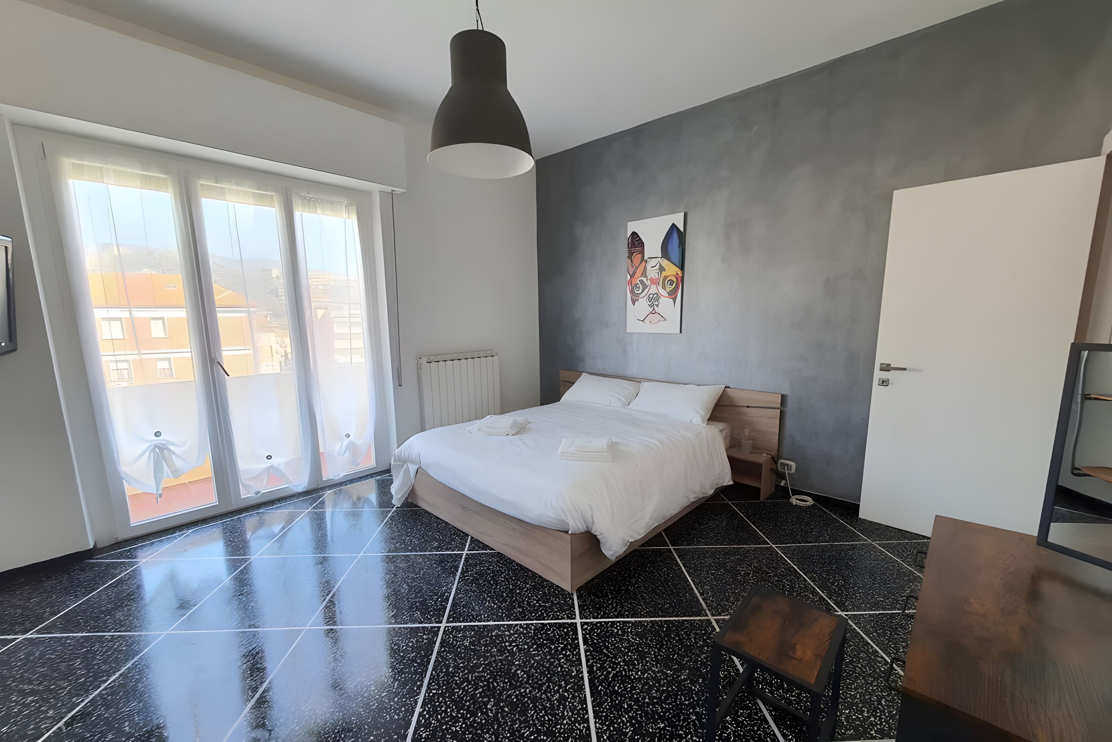 Une chambre à coucher moderne avec un grand lit, une vue sur l’extérieur et un tableau accroché au mur.