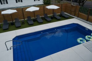A swimming pool with a diving board, lounge chairs, and umbrellas. - Ibiza Bohemia | Pool | Downtown ILM (Wilmington)