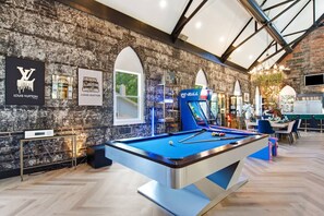 A billiards table in a room with a brick wall and arched windows. - Games| Pool | Sleeps 12 | Chef Kitchen (Wilmington)