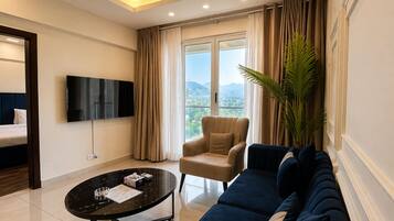 A modern living room with a sofa, armchair, and a flat-screen TV.