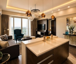 A modern living room with a sofa, a coffee table, a TV, and a large window. - Elysium Serviced Apartment (Islamabad)