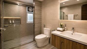 Ein modernes Badezimmer mit Glasdusche, Toilette und Waschtisch mit Spiegel.