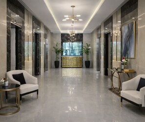 A modern lobby with a reception desk, seating area, and a large window. - Elysium Serviced Apartment (Islamabad)