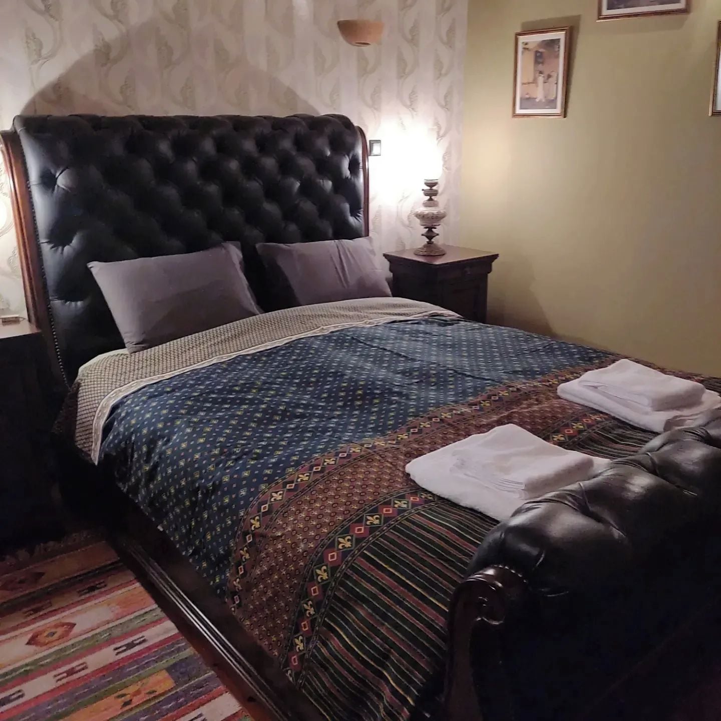 Una cama con una colcha estampada, un cabecero y almohadas.