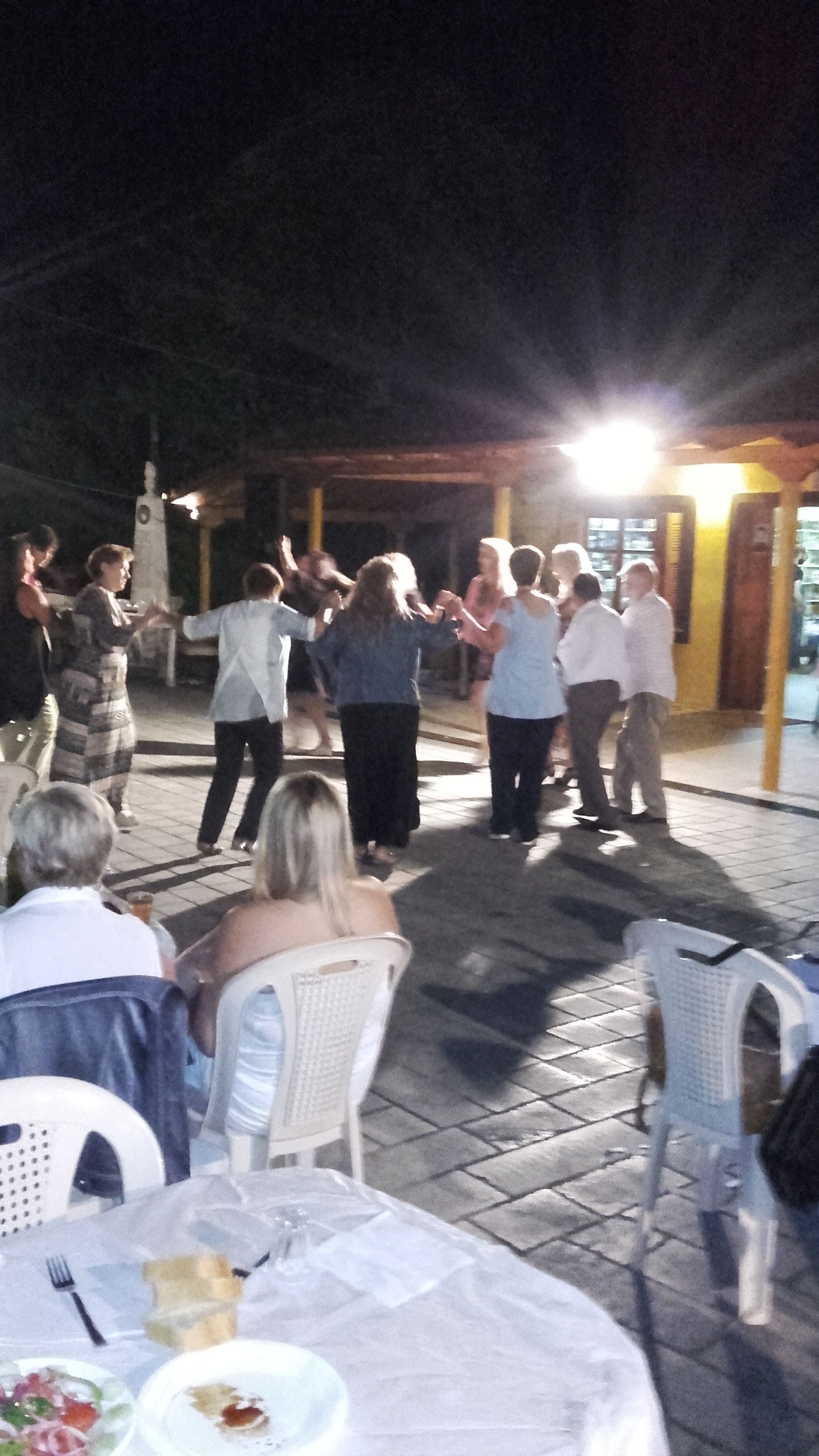 Un grupo de personas bailando al aire libre de noche.