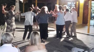 Un grupo de personas bailando al aire libre de noche.