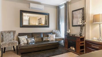 Una sala de estar moderna con un sofá, una silla, una chimenea y un espejo grande.