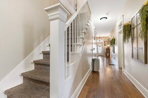 A staircase with white railings and carpeted steps leading to a landing. - The Branson Hotel (Branson)