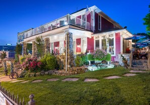 A two-story building with a balcony, stone pillars, and a well-maintained garden. - The Branson Hotel (Branson)