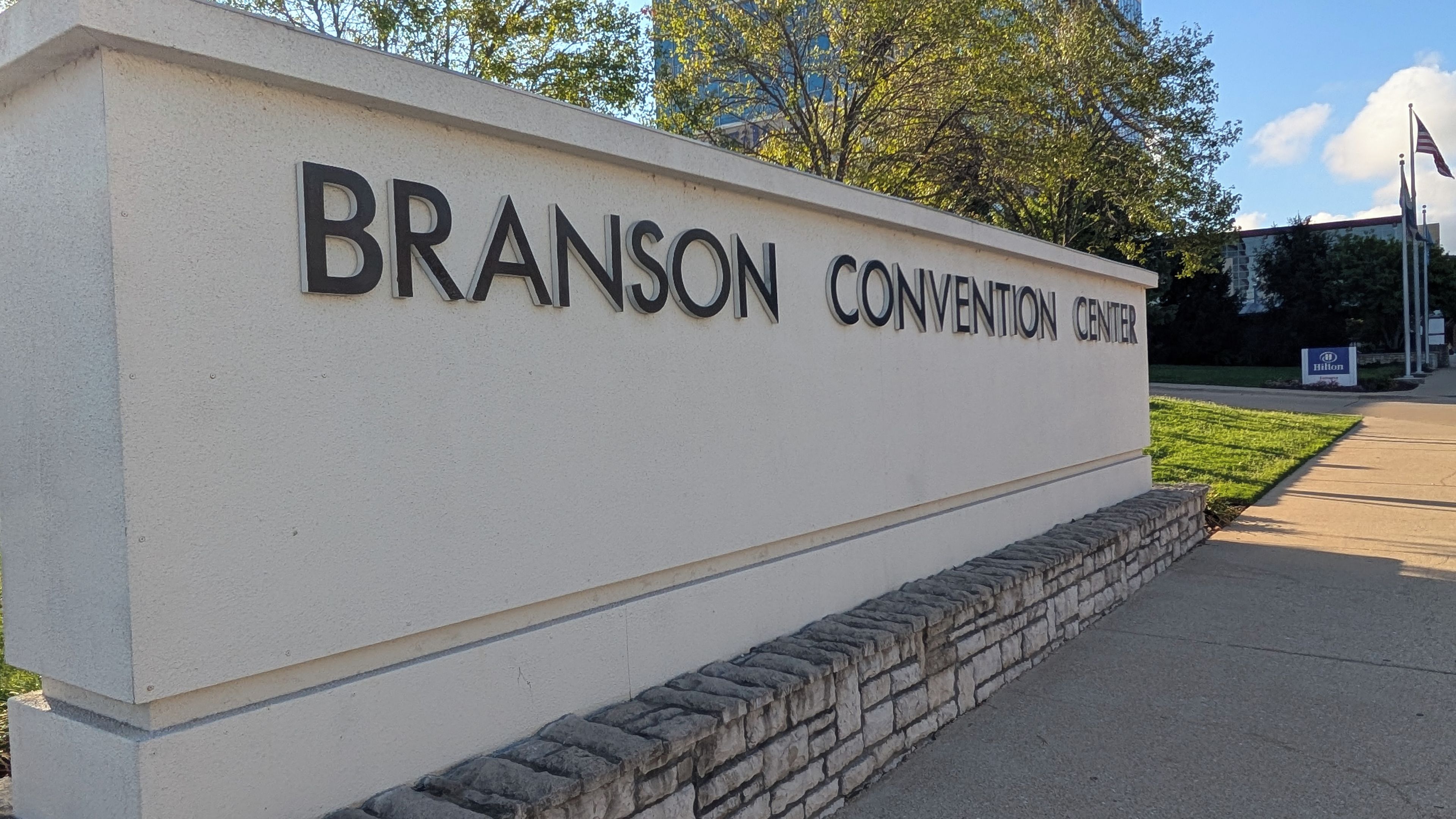 Señal del Branson Convention Center, con un cielo despejado y árboles al fondo.