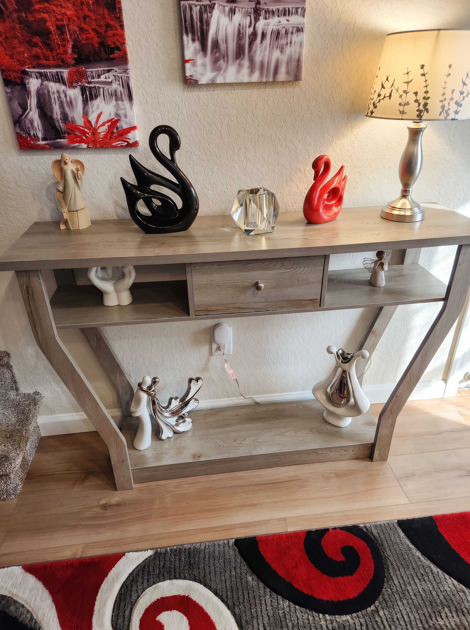 A wooden desk with decorative items and a lamp.