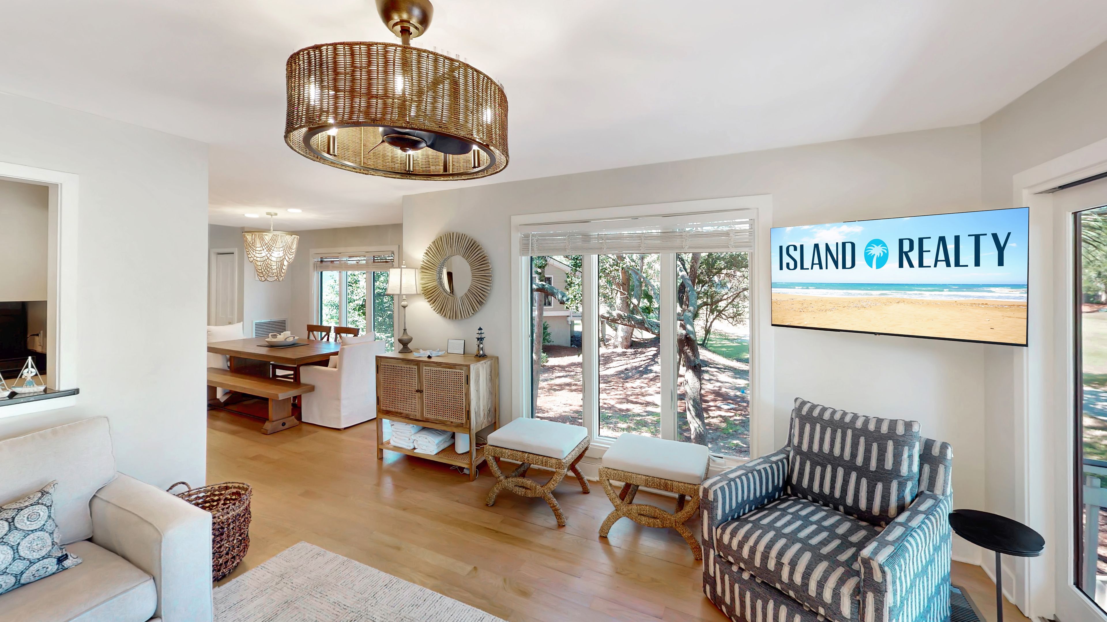 A spacious living room with a large window, a television, and a dining area with a table and chairs.