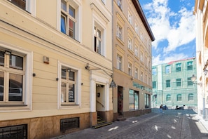A street with buildings, a pedestrian, and a scooter. - Aksamitna Przystań przy Starym Rynku (Poznań)