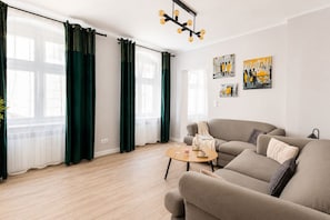 A modern living room with a sofa set, a coffee table, and artwork on the wall. - Aksamitna Przystań przy Starym Rynku (Poznań)