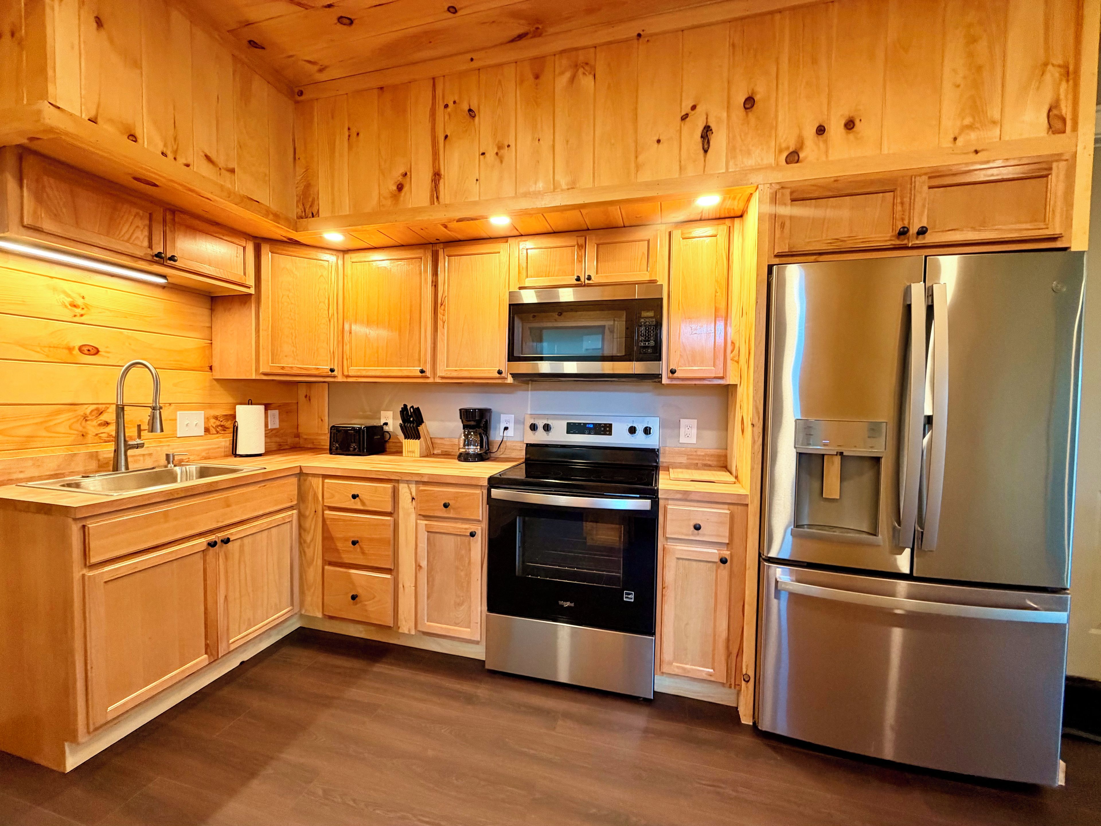 A kitchen with wooden cabinets, stainless steel appliances, and a built-in oven.