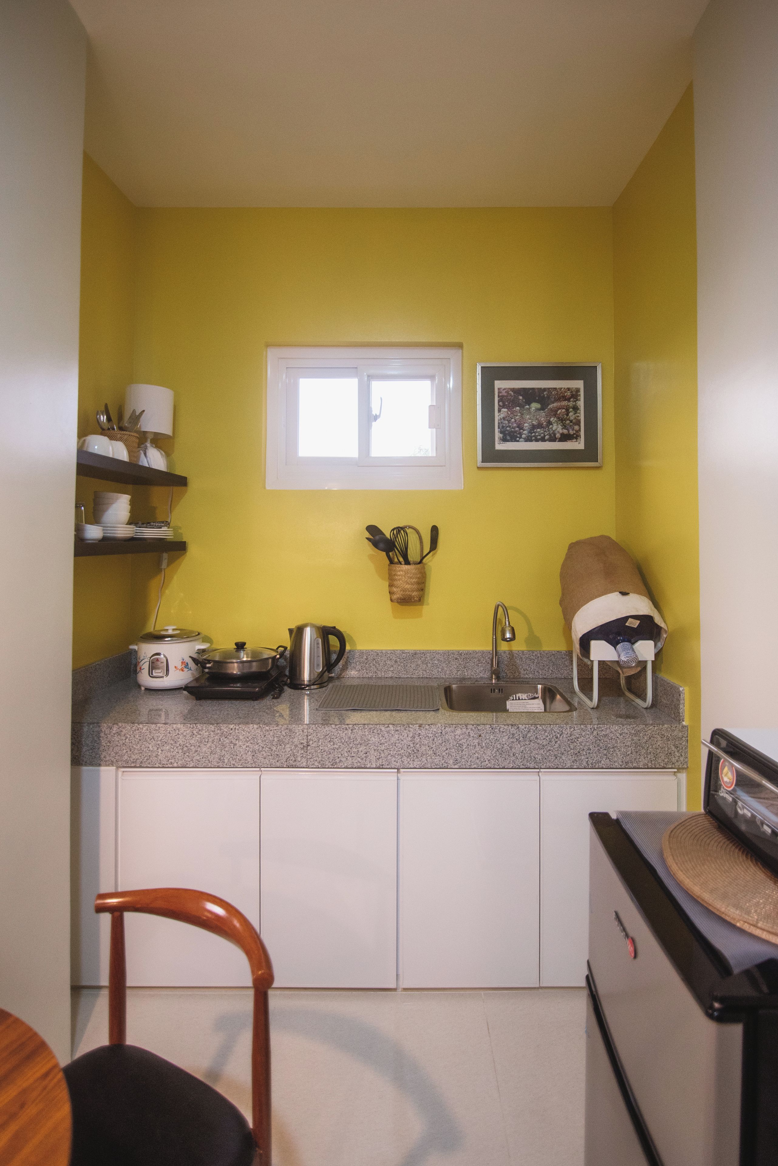 A compact kitchen with a window, a sink, and a stove.