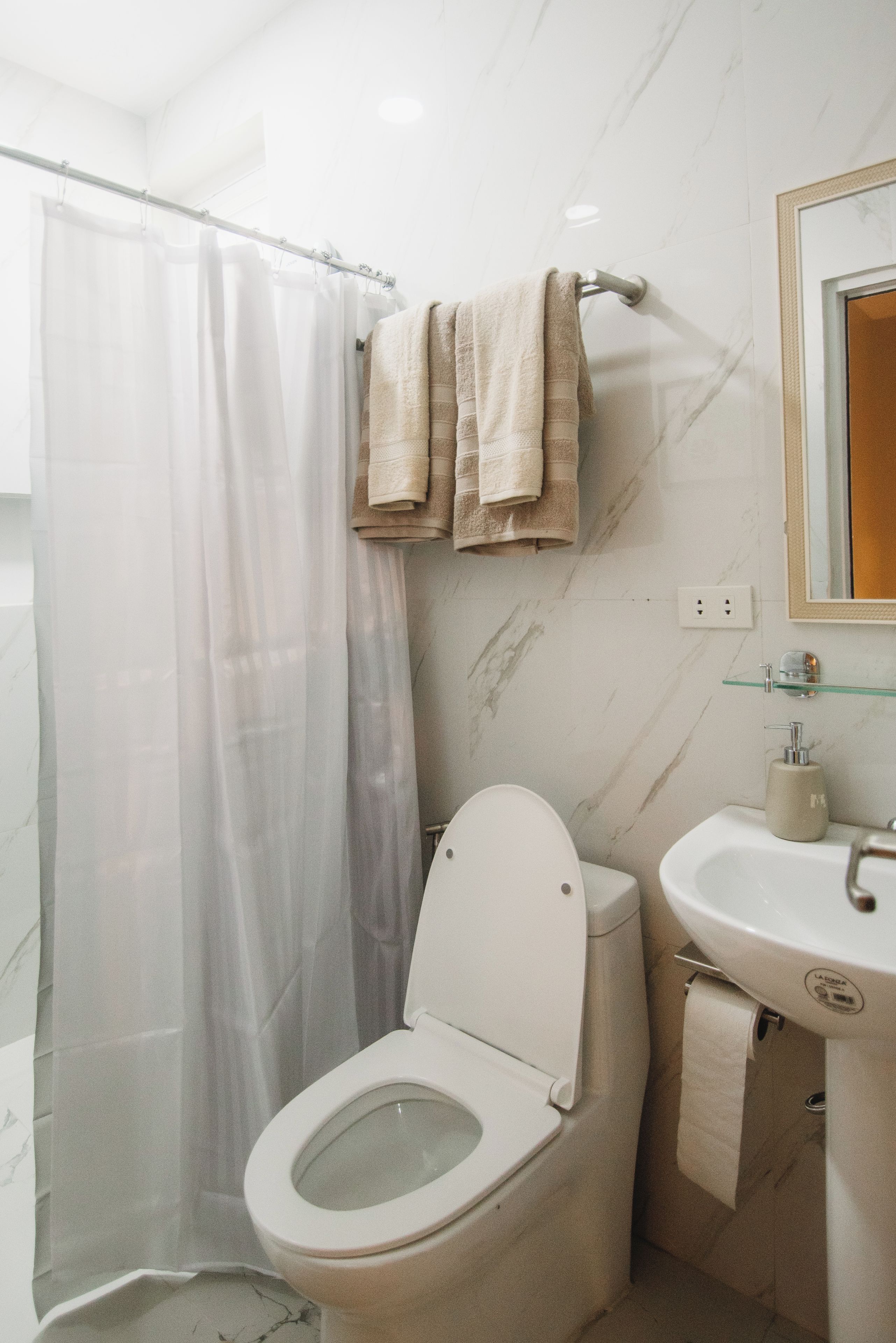 A bathroom with a toilet, a sink, and a shower curtain.