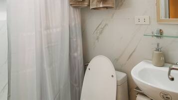 A bathroom with a toilet, a sink, and a shower curtain.
