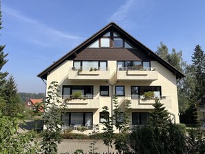 A two-story building with balconies, large windows, and a sloped roof. - Holiday Apartment With 1 Bedroom (Braunlage)