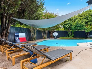 A pool area with lounge chairs, a basketball hoop, and a shaded canopy. - Jungle Oasis - Pool + Hot Tub + Game Rooms (Richardson)