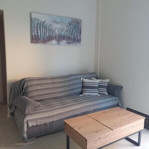 A living room with a sofa, a coffee table, and a painting on the wall. - Yard House 284 Kalamata (Kalamata)