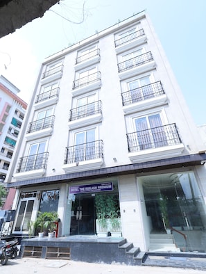 Un hotel de varios pisos con balcones, una entrada visible y un letrero que indica que es el Kailash Premium Hotel.