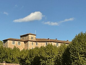 A large stone building with multiple windows and a central tower, surrounded by dense greenery. - Holiday Home With 1 Bedroom (Entrecasteaux)