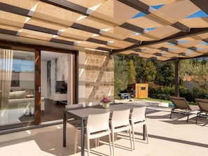 A covered outdoor patio with a dining table and chairs, a barbecue grill, and a small wooden structure. - Casa Veritas With Pool (Visnjan)