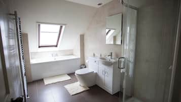 A modern bathroom with a bathtub, toilet, and sink.