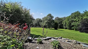 Un jardin bien entretenu, agrémenté de diverses plantes et d’une statue de flamant décorative.