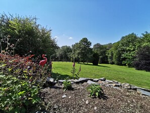 A well-maintained garden with a variety of plants and a decorative flamingo statue.