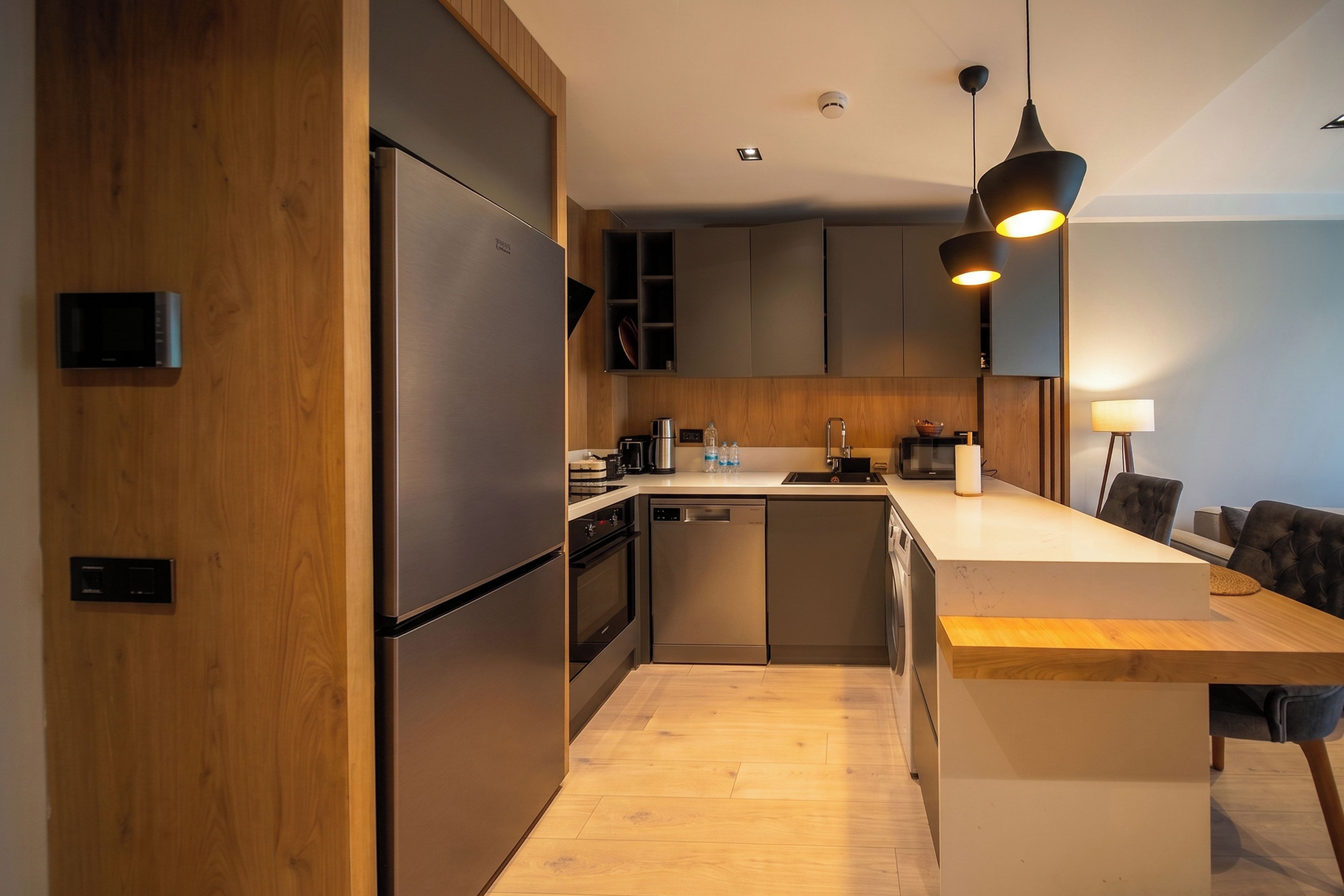 A modern kitchen with stainless steel appliances, wooden cabinetry, and a central island with seating.