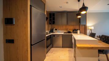 A modern kitchen with stainless steel appliances, wooden cabinetry, and a central island with seating.