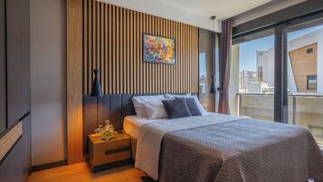 Un dormitorio moderno con cama, mesita de noche y un ventanal grande.