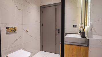 A modern bathroom with a toilet, a sink, and a mirror.