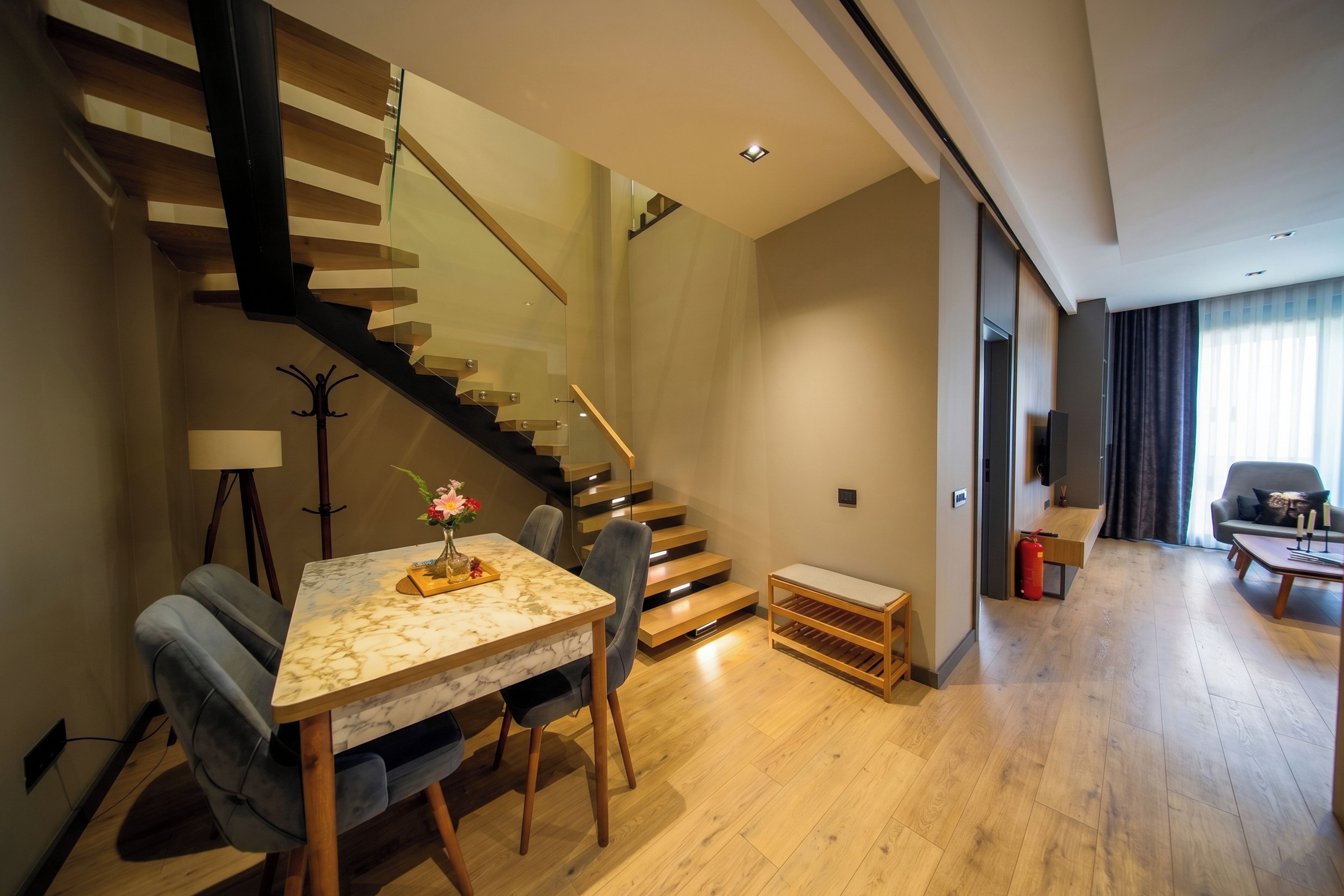 A modern living room with a marble table, a sofa, and a staircase.