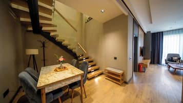A modern living room with a marble table, a sofa, and a staircase.