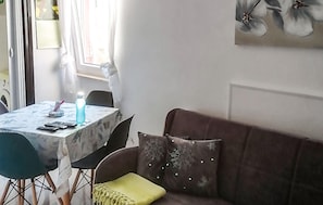 A dining area with a table, chairs, a water bottle, and a candle. - 1 bedroom stunning apartment in Cres (Cres)