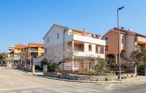 A residential street with houses, a stone wall, and a street lamp. - 1 bedroom stunning apartment in Cres (Cres)