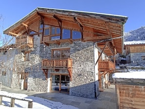 A multi-story wooden building with stone walls, balconies, and large windows. - Nature Ski Lodge Sterwen (Landry)