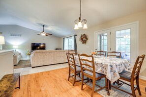 A dining area with a wooden table, chairs, and a ceiling fan.