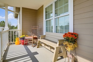 A porch with a wooden bench, a chair, and a potted plant. - Screened Porch, Fire Pit! Family Home Near K-state (Manhattan)