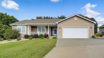 A single-story house with a front porch, a garage, and a well-maintained lawn.