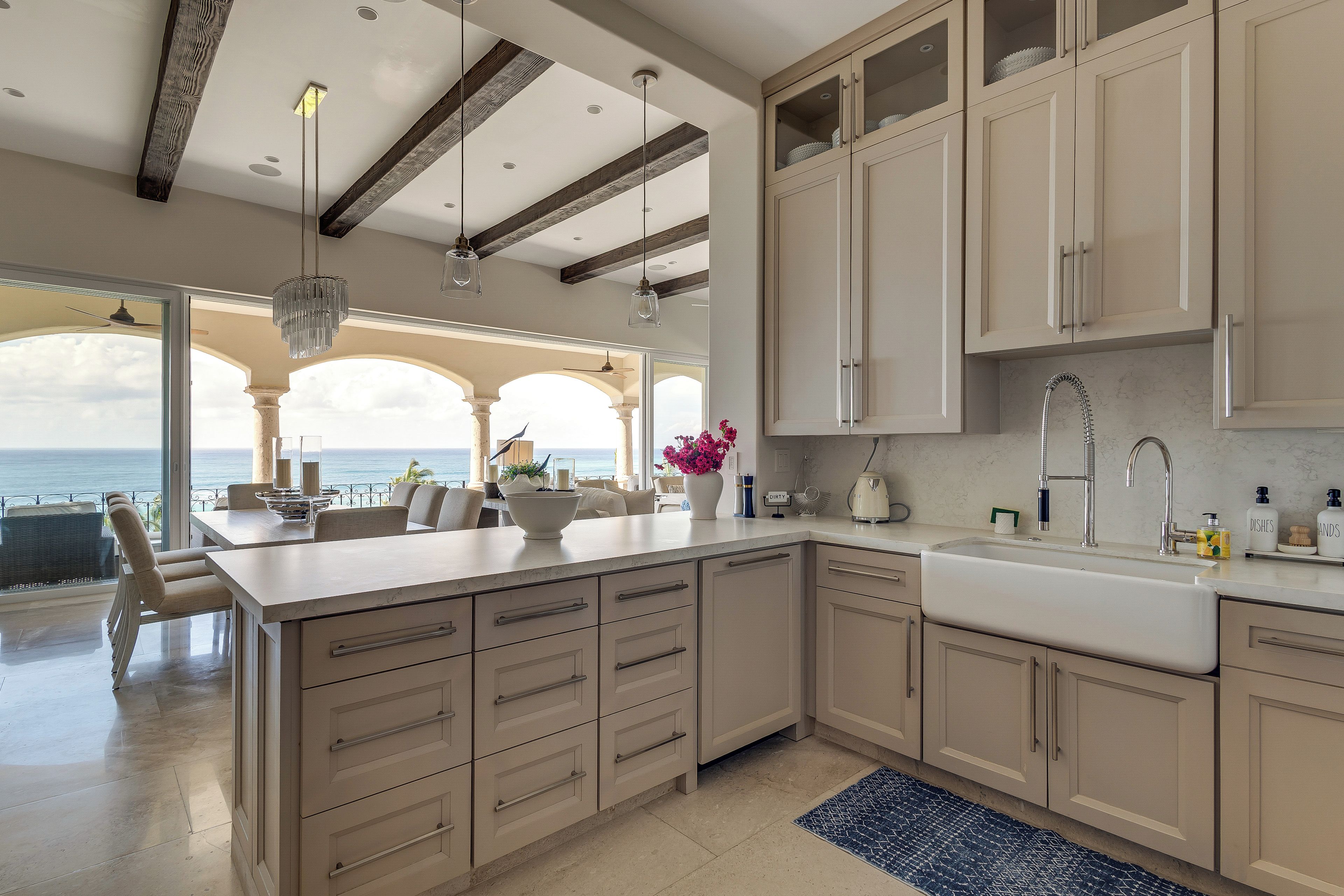 A spacious kitchen with a large island, modern appliances, and a view to the outside.