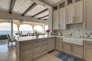 A spacious kitchen with a large island, modern appliances, and a view to the outside.